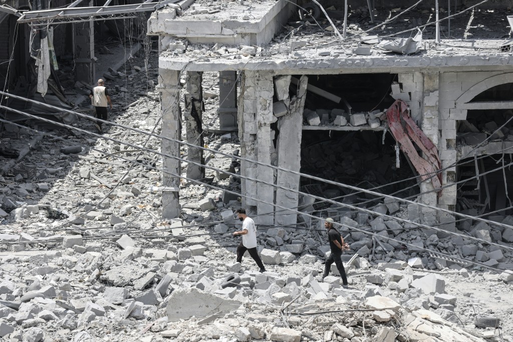 Photo by MAHMOUD ZAYYAT / AFP People make their way through the heavily damaged historic market of Nabatieh as residents displaced by fighting return to southern Lebanon on June 15, 2026.