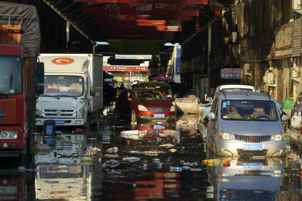 Vehicles sit in floodwaters at the Yubei Agricultural and Aquatic Products World in Xinxiang in central China's Henan Province, Monday, July 26, 2021.