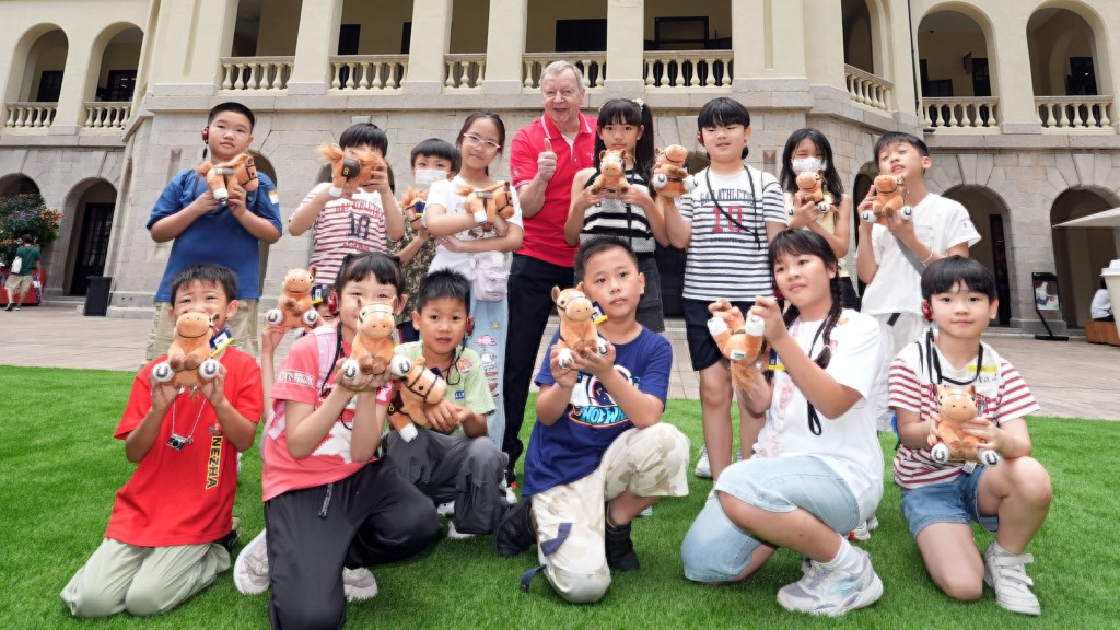 Winfried Engelbrecht-Bresges, Chief Executive Officer of The Hong Kong Jockey Club (5th right back row) and volunteers lead underprivileged families on a docent-led tour of Tai Kwun, introducing its history and heritage features.