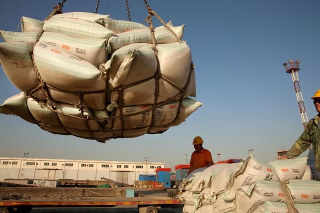 Workers transport imported soybean products at a port in Nantong, Jiangsu province, China April 9, 2018. REUTERS/Stringer