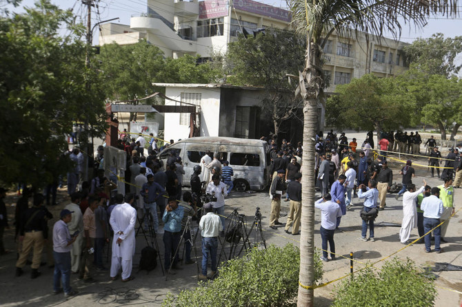 Police officers and journalists gather near a burned van at the site of an explosion in Karachi. (AP) Police officers and journalists gather near a burned van at the site of an explosion in Karachi. (AP)