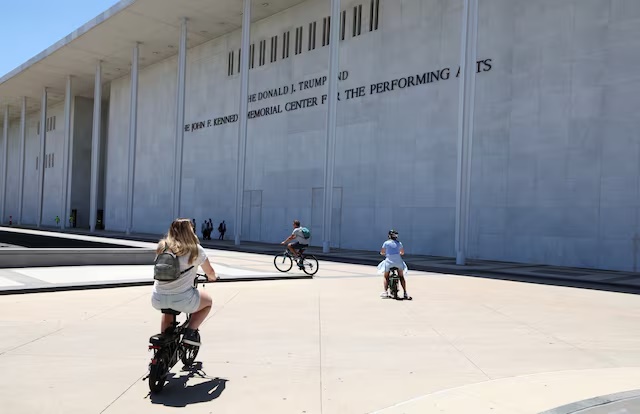 Cyclists ride by the John F. Kennedy Memorial Center for the Performing Arts, renamed The Donald J. Trump and The John F. Kennedy Memorial Center for the Performing Arts by the Trump administration, after a federal judge ordered that President Trump’s name be removed from the building, in Washington, D.C., U.S., June 3, 2026. REUTERS/Kevin Lamarque