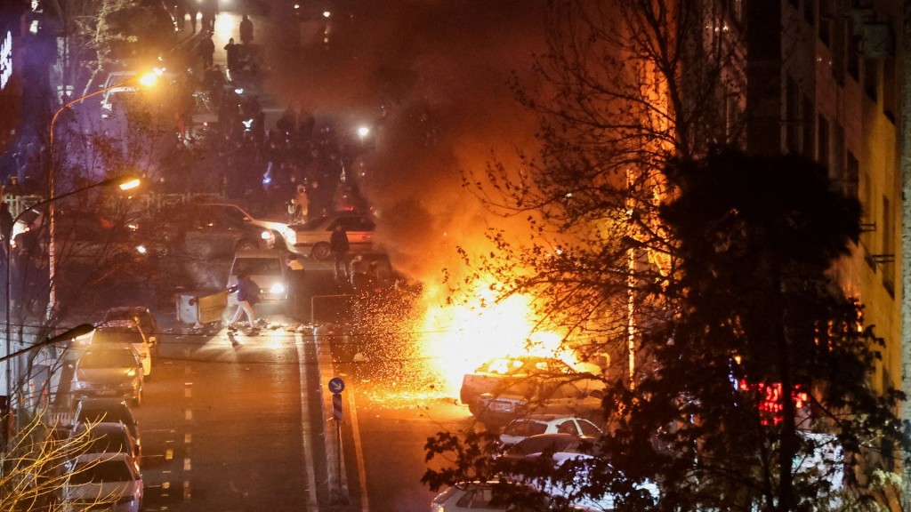 Cars burn in a street during a protest in Tehran. Reuters