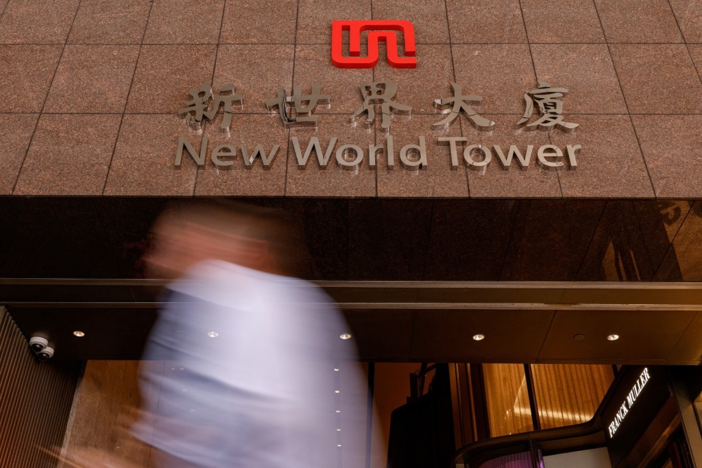 A man walks past the headquarters of New World Development at New World Tower, in Hong Kong, China. Reuters