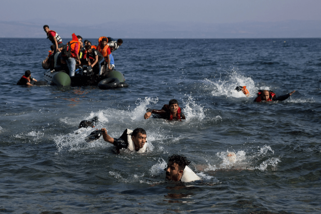 Migrants, whose boat stalled while crossing from Turkey to Greece, swim to the island of Lesbos, Greece, on Sept. 20, 2015. (AP Photo/Petros Giannakouris, File)