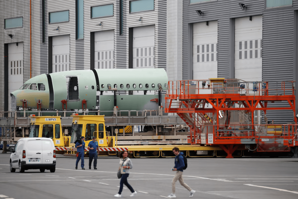 Employees walk past a fuselage section of an A320 Airbus airplane at the Airbus facility in Montoir-de-Bretagne near Saint-Nazaire, France, July 1, 2020. REUTERS/Stephane Mahe