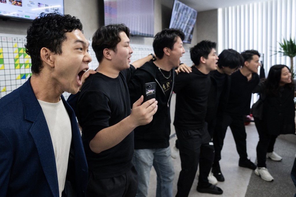 Photo by ANDREW CABALLERO-REYNOLDS / AFP  Employees chant work targets during a daily meeting, part of routine corporate practices aimed at boosting productivity, at the Global Partners office in Tokyo on June 1, 2026.