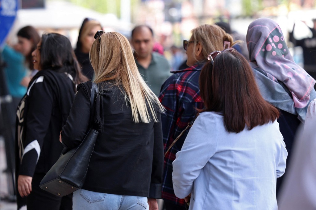Iranian women walk along a busy street in Tehran on April 25, 2026. (Photo by AFP)