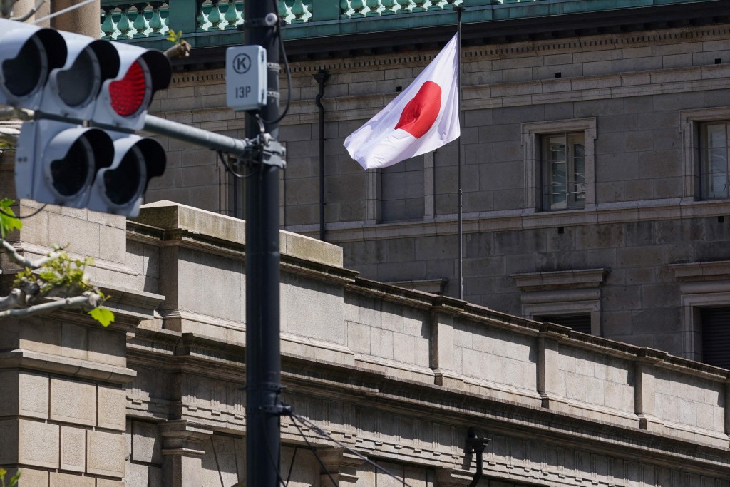 The Japanese national flag flutters in the wind on part of the Bank of Japan (BoJ) headquarters in Tokyo on April 28, 2026. AFP