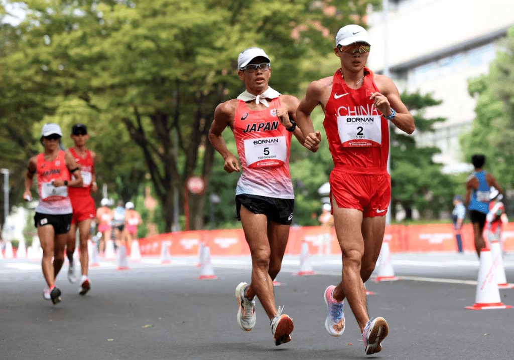 Asian Games - Aichi-Nagoya 2026 - Race Walk - Aichi Prefectural Government Office and Nagoya City Hall Loop Course, Nagoya, Japan - September 23, 2026 Japan's Toshikazu Yamanishi and China's Shengji Shi in action during the men's half marathon race walk REUTERS/Andrew Boyers
