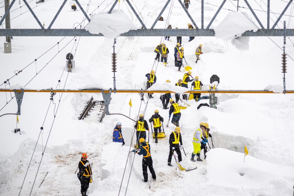 Staff members shovel snow covered rail tracks at Shin Aomori station in Aomori city, as the local train services are suspended due to heavy snow in Aomori prefecture on January 30, 2026. (Photo by Philip FONG / AFP)