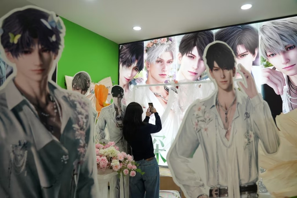A woman takes pictures near displays showing characters from the mobile game "Love and Deepspace" at a mall in Guangzhou, Guangdong province, China February 1, 2026. REUTERS/Nicoco Chan 