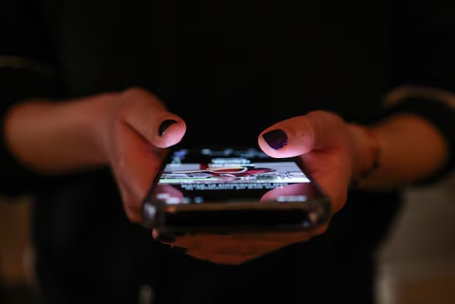 A girl checks social media posts on her phone, as Greece is set to ban under-15s from social media in European crackdown, in Athens, Greece, April 1, 2026. REUTERS/Louisa Gouliamaki