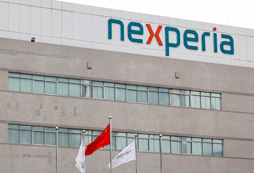 Flags fly next to a logo of Nexperia at the facade of its factory amidst a shortage of chip supply caused by a diplomatic standoff between China and Netherlands over the company, in Dongguan, Guangdong province, China, November 7, 2025. REUTERS/Maxim Shemetov