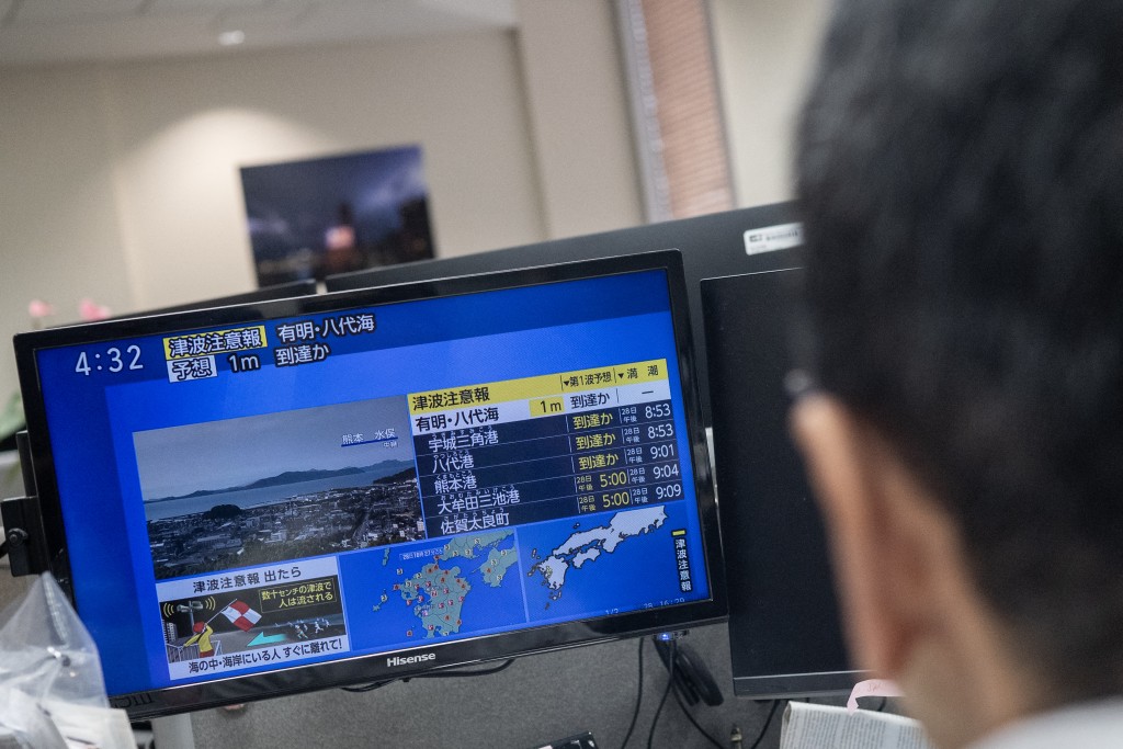 Photo by ANDREW CABALLERO-REYNOLDS / AFP  Reporters watch the news showing a large quake and possible one meter tsunami wave in Southern Japan, from an office in Tokyo on July 28, 2026.