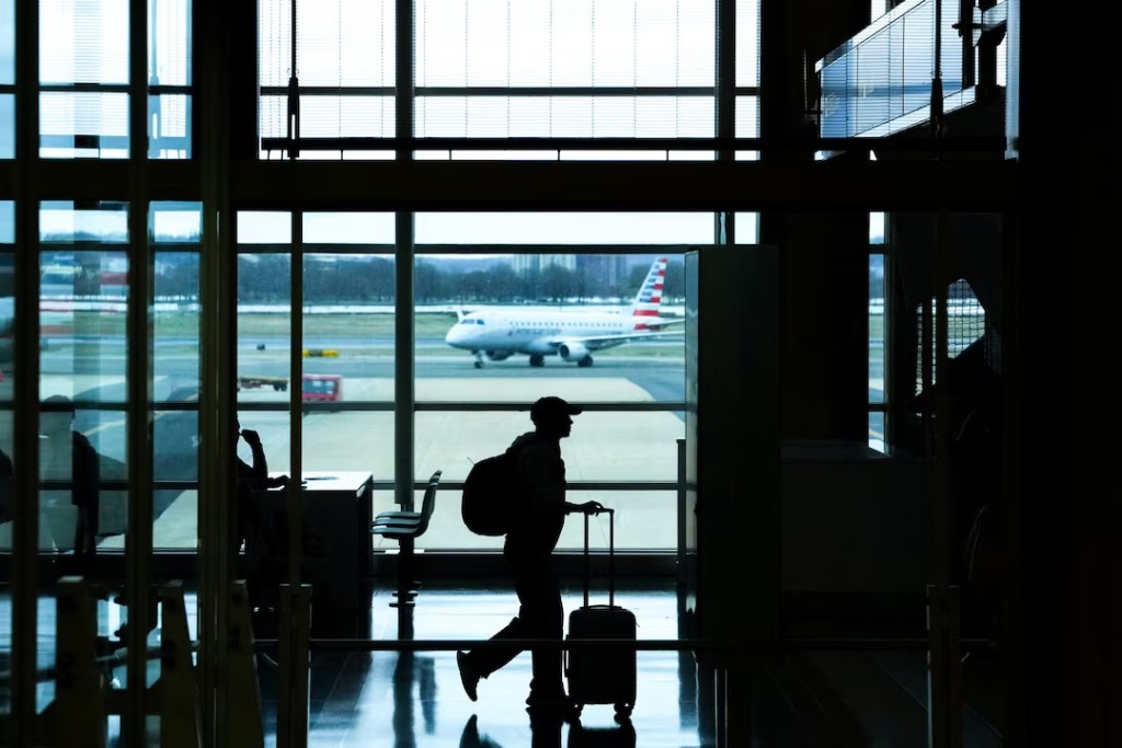 A passenger walks through Ronald Reagan International Airport in Arlington, Virginia., U.S., March 15, 2026. REUTERS/Aaron Schwartz