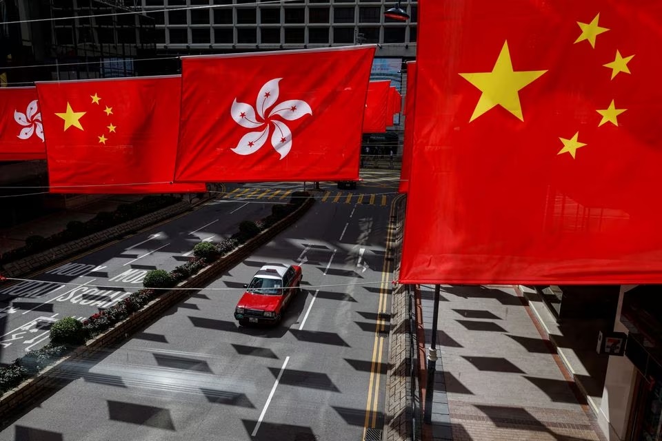 A taxi drives under Chinese and Hong Kong flags outside a shopping mall in Hong Kong, China July 5, 2023. REUTERS/Tyrone Siu/File Photo A taxi drives under Chinese and Hong Kong flags outside a shopping mall in Hong Kong, China July 5, 2023. REUTERS/Tyrone Siu/File Photo