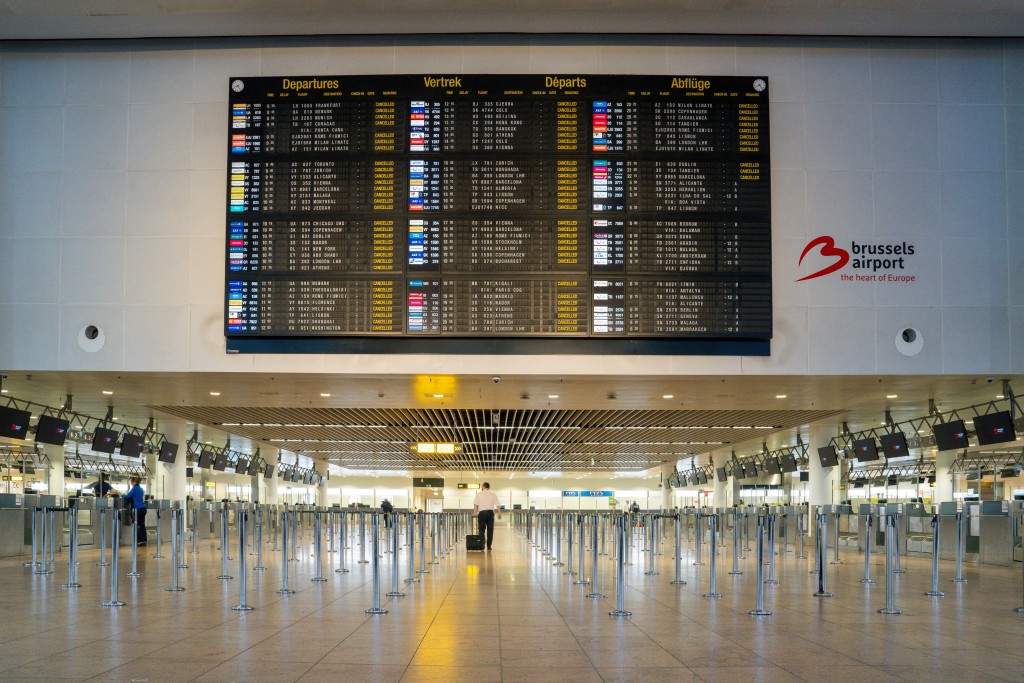 This photograph shows a few passengers at the Brussels Airport during a national strike, in Zaventem on October 14, 2025, as all the departing flights are cancelled as part of a national day of action to protest against the austerity of the federal Arizona government. (Photo by Marius Burgelman / BELGA / AFP) / BELGIUM OUT