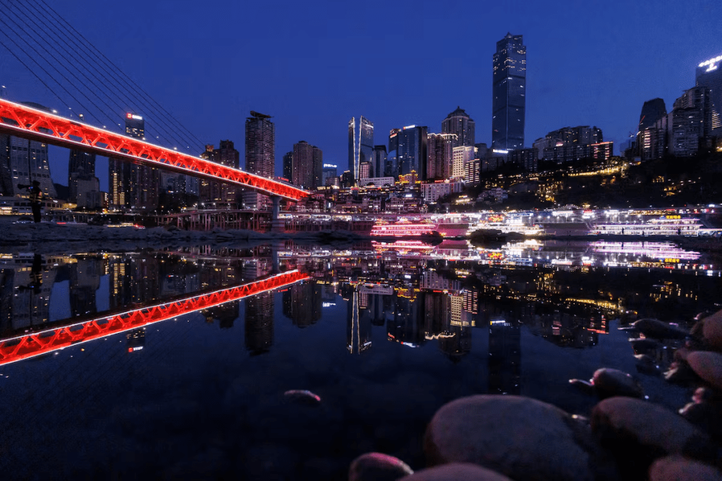 The city skyline is reflected in a pool left on the Jialing river, a tributary of the Yangtze, in Chongqing, China, August 20, 2022. REUTERS/Thomas Peter/File Photo