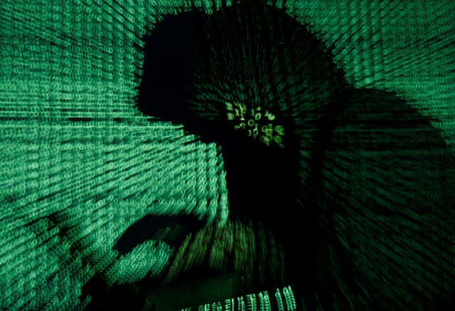 A man holds a laptop computer as cyber code is projected on him in this illustration picture taken on May 13, 2017. REUTERS/Kacper Pempel/Illustration/File Photo