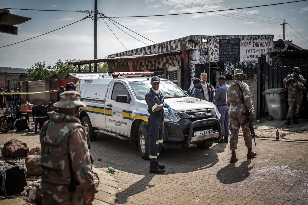 Members of South Africa's Forensic Pathology Service and South African National Defence Force (SANDF) inspect and secure the scene where gunmen armed with assault rifles stormed a bar in Johannesburg on September 27, 2026. (AFP)