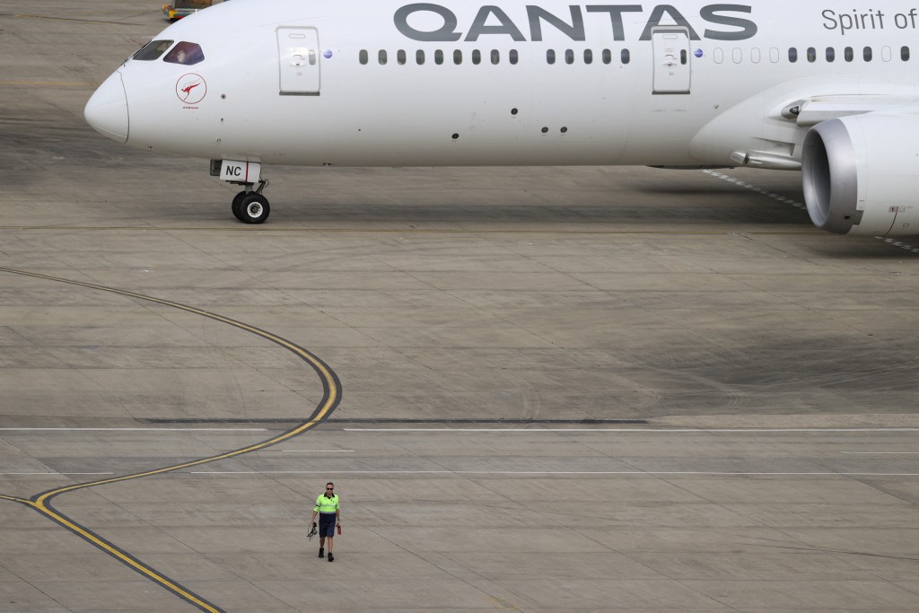 A ground worker walking near a Qantas plane is seen from the international terminal at Sydney Airport, as countries react to the new coronavirus Omicron variant amid the coronavirus disease (COVID-19) pandemic, in Sydney, Australia, November 29, 2021.  REUTERS