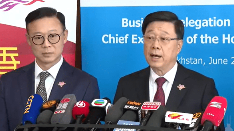 Chief Executive John Lee Ka-chiu (right) addressing the press in Kazakhstan on Tuesday.