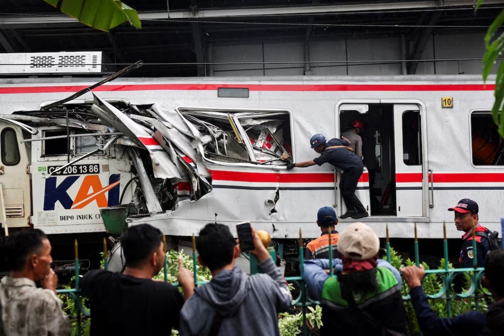  People watch as a technician works at the site after a deadly collision between a commuter line train and a long-distance train, in Bekasi, on the outskirts of Jakarta, Indonesia, April 28, 2026. REUTERS/Willy Kurniawan