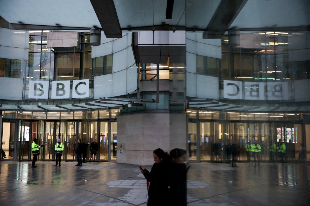 FILE PHOTO: People stand outside BBC Broadcasting House, after Director General Tim Davie and CEO of BBC News Deborah Turness resigned on Sunday, November 9, following accusations of bias at the British broadcaster, including in the way it edited a speech by U.S. President Donald Trump, in London, Britain, November 14, 2025. REUTERS/Isabel Infantes/File Photo