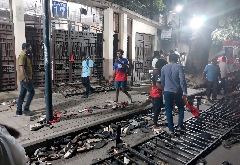 People walk past scattered shoes left behind following a stampede outside a cricket stadium in Bengaluru, India, June 4, 2025. (Reuters)