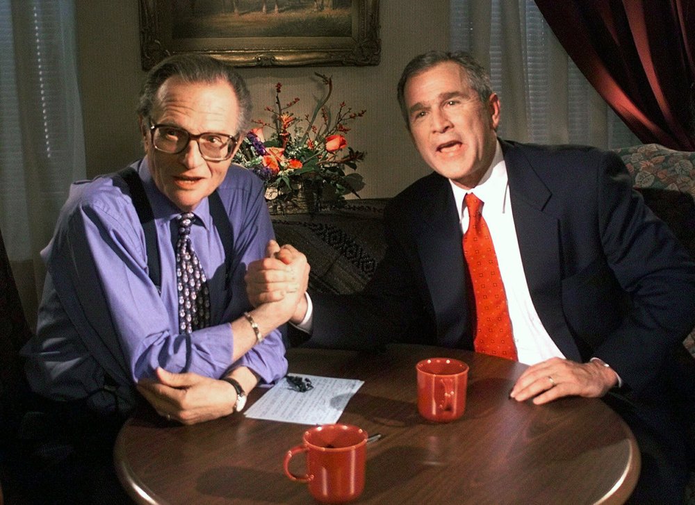 In this December 16, 1999 file photo, Republican presidential candidate Texas governor George W. Bush jokes with CNN's Larry King after finishing the  show from the Wildhorse Saloon in Nashville, Tennessee. 