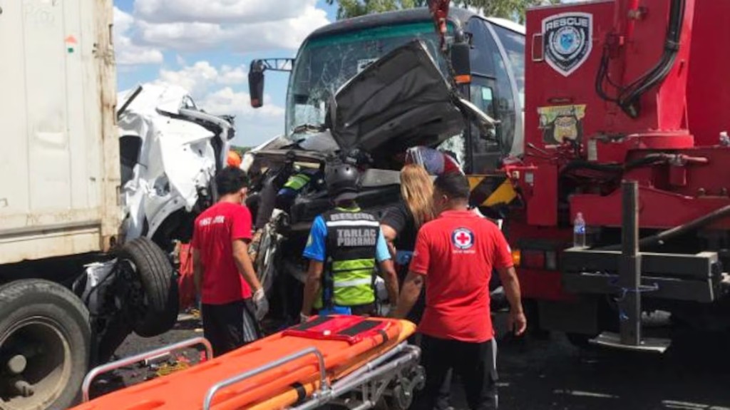 In this handout photo provided by the Philippine Red Cross, rescuers check the site of a multiple-vehicle collision after a speeding passenger bus slammed into a row of vehicles lined up at a highway toll booth killing about a dozen people in Tarlac city, north of Manila, Philippines on Thursday May 1, 2025. (Philippine Red Cross via AP)
