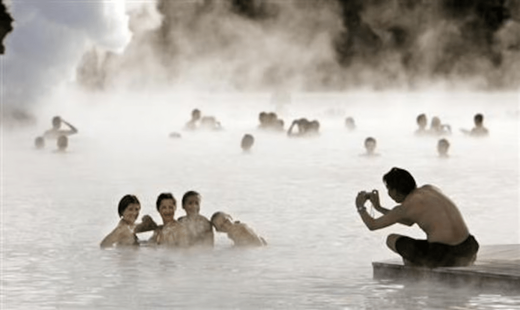 Bathers pose for a photo as they swim in the geothermal hot springs at Iceland's Blue Lagoon near Grindavik September 30, 2006. REUTERS/Bob Strong