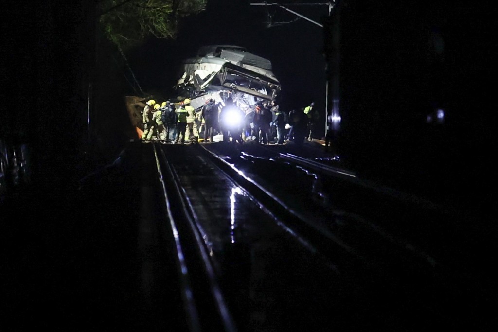 Photo by JOSEP LAGO / AFP  Firefighters and rescue personnel work at the site where at least one person died and four were seriously injured when a regional service train collided with a collapsed wall between Sant Sadurni d'Anoia and Gelida, near Barcelona, early January 21, 2026.