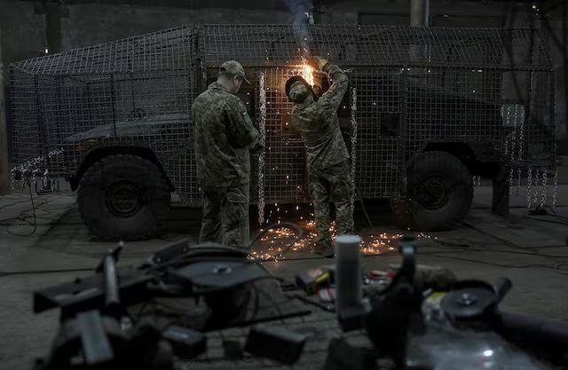 Servicemen of the 25th Separate Airborne Brigade of the Armed Forces of Ukraine install a grille as combat drones protection on a HMMWV (High Mobility Multipurpose Wheeled Vehicle) in a workshop, amid Russia's attack on Ukraine, in Donetsk region, Ukraine June 4, 2025. REUTERS/Anatolii Stepanov