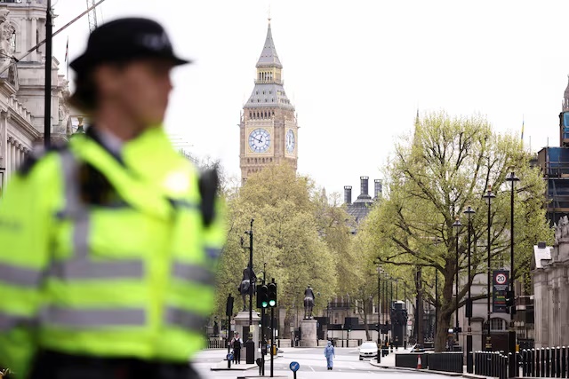 A forensic official and police officers work at a cordon on Whitehall in Westminster after the road was closed by police following an incident involving the arrest of a man near Downing Street, in London, Britain, April 18, 2022. REUTERS/Henry Nicholls/File Photo