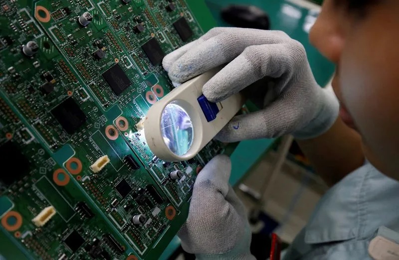A woman looks through a magnifying glass to check errors of a printer circuit board at Manutronics Factory in Bac Ninh province. (File Photo) A woman looks through a magnifying glass to check errors of a printer circuit board at Manutronics Factory in Bac Ninh province. (File Photo)