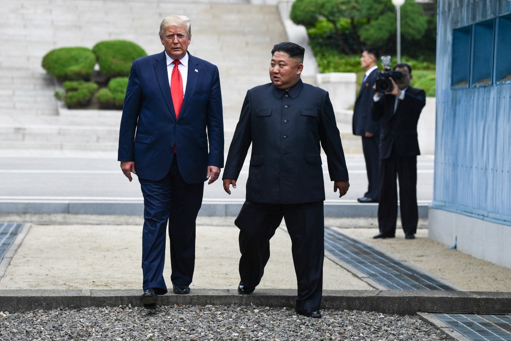 Photo by BRENDAN SMIALOWSKI / AFP North Korea's leader Kim Jong Un and US President Donald Trump cross south of the Military Demarcation Line that divides North and South Korea, after Trump briefly stepped over to the northern side, in the Joint Security Area (JSA) of Panmunjom in the Demilitarized zone (DMZ) on June 30, 2019.