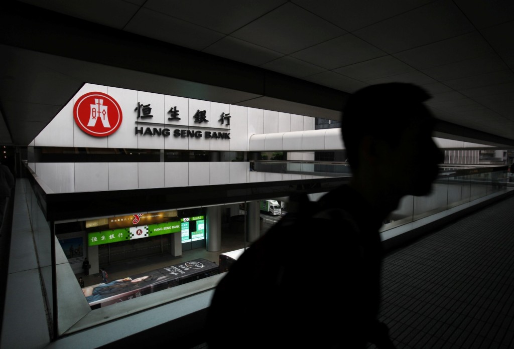 A man walks on footbridge outside Hang Seng Bank headquarters in Hong Kong March 27, 2013.  REUTERS/Bobby Yip