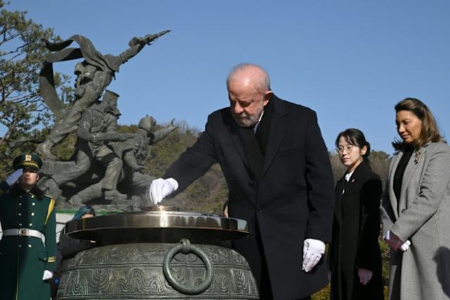 Brazil's President Luiz Inacio Lula da Silva burns incense as his wife Rosangela looks on during a state visit to Seoul on Monda
