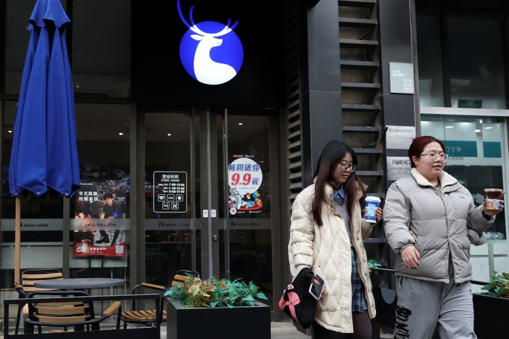 Women hold cups of coffee as they leave a Luckin Coffee store in Beijing, China December 8, 2023. REUTERS