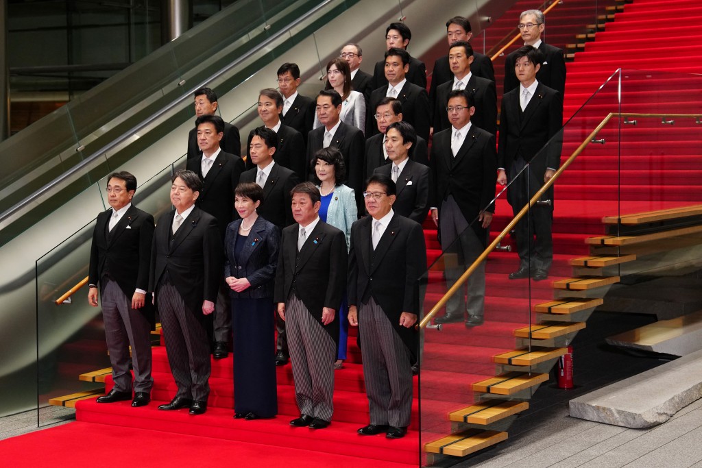 Japan's new Prime Minister Sanae Takaichi (C, front row) poses during a photo session with members of her cabinet at the prime minister's office in Tokyo on October 21, 2025. (Photo by Jia Haocheng / POOL / AFP)