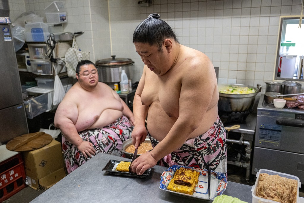 Photo by MATHIAS CENA / AFP  This picture taken on January 8, 2026 shows sumo wrestlers cooking a "chanko" meal after morning training at the Kise sumo stable in Tokyo.
