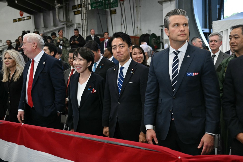 US Ambassador to Japan George Glass (2nd L), Japan's Prime Minister Sanae Takaichi (3rd L), Japan's Defense Minister Shinjiro Koizumi (2nd R), and US Defense Secretary Pete Hegseth (R) react to US President Donald Trump's speech in front of US Navy personnel on board the US Navy's USS George Washington aircraft carrier at the US naval base in Yokosuka on October 28, 2025. (Photo by ANDREW CABALLERO-REYNOLDS / AFP)