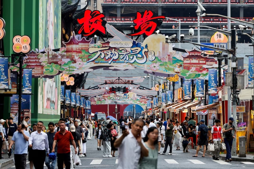 People walk along a shopping street in Shanghai, China, July 1, 2026. REUTERS/Go Nakamura