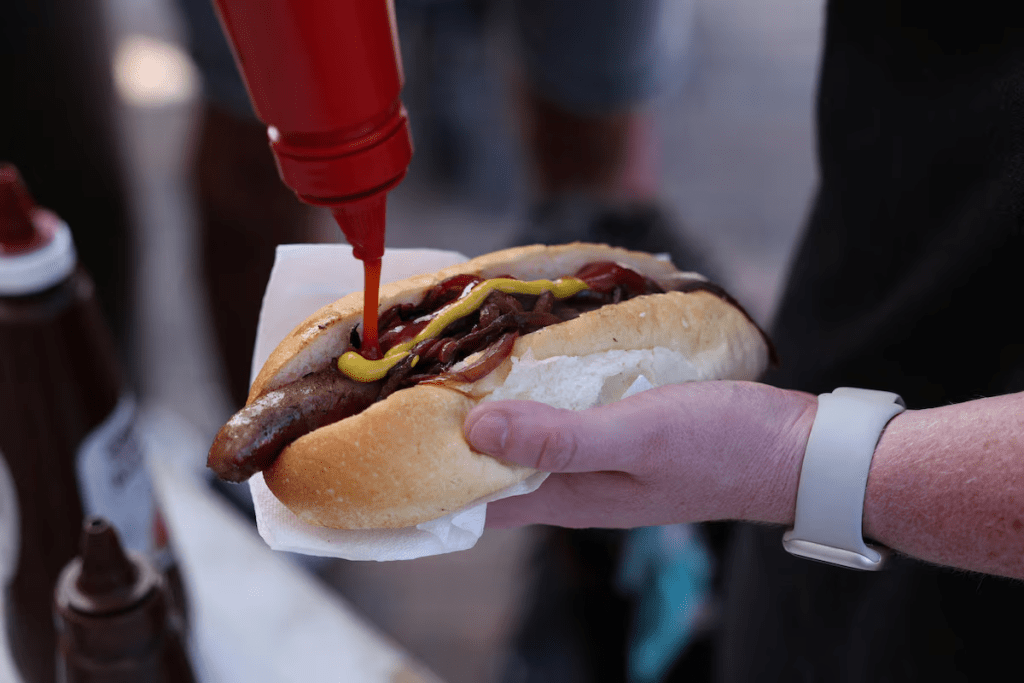 A voter puts ketchup on a so-called "democracy sausage" on the day of the Australian federal election, in Sydney, Australia, May 3, 2025. REUTERS/Hollie Adams