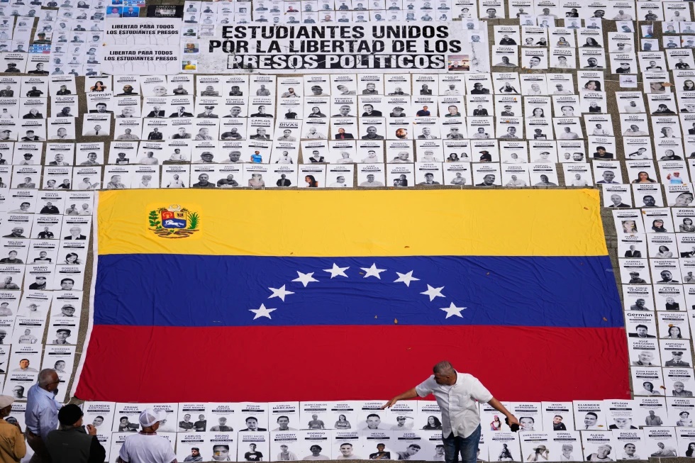 Students lay out photos of people they consider political prisoners at the Central University of Venezuela in Caracas, Venezuela, Tuesday, Jan. 13, 2026. (AP Photo/Matias Delacroix)