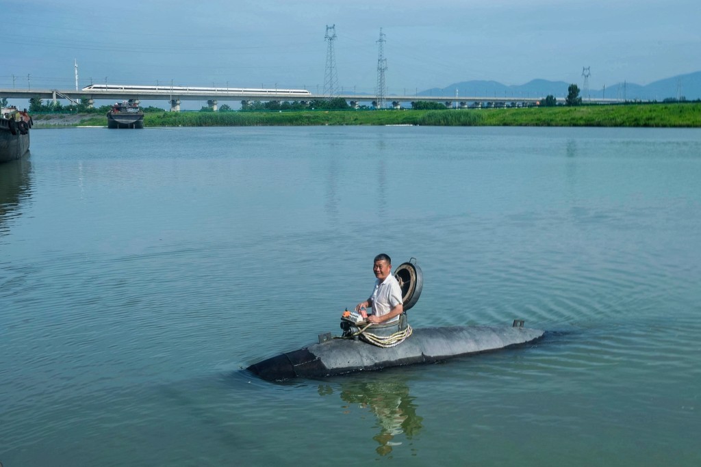 This photo taken on July 2, 2025 shows Chinese farmer Zhang Shengwu posing in his homemade submarine in a river in Hanshan county, in China’s eastern Anhui province. (AFP)