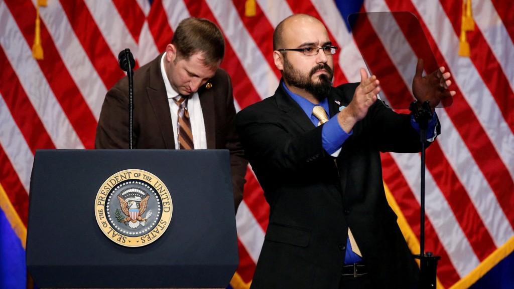 Gabriel Perez adjusts the teleprompter before U.S. President Donald Trump delivers remarks. Reuters