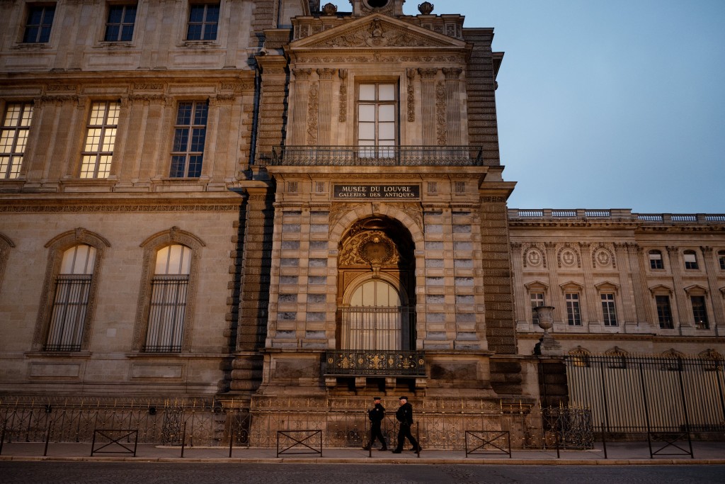 Police officers walk next to posts newly installed on the sidewalk along the Louvre Museum, on Quai Francois Mitterrand, in Paris on December 12, 2025, a few weeks after thieves used a furniture lift to break into the museum. (AFP)